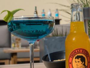 a glass of beer next to a bottle of soda at Morada Strandhotel Ostseebad Kühlungsborn in Kühlungsborn
