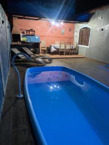 a swimming pool in a room with a table and chairs at Casa em Peruibe 3 dormitórios sendo 1 suite Pe na Areia in Peruíbe