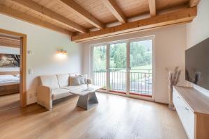 sala de estar con sofá y ventana grande en Residenz zur Hackenschmiede, en Mauterndorf