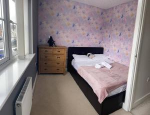 um pequeno quarto com uma cama e uma cómoda em New beautiful house in a perfect location em Newcastle under Lyme
