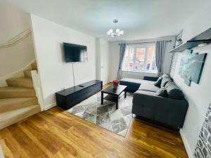 uma sala de estar com um sofá e uma mesa em New beautiful house in a perfect location em Newcastle under Lyme