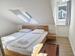 een slaapkamer met 2 bedden en een raam bij Dünenpark Binz - Komfort Ferienwohnung mit 2 Schlafzimmern und Balkon im Dachgeschoss 047 in Binz