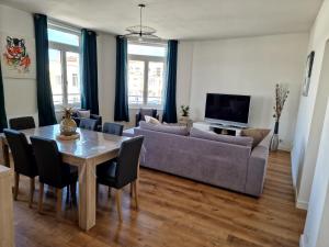 een woonkamer met een bank en een tafel met stoelen bij Appartement Dunkerque in Duinkerke