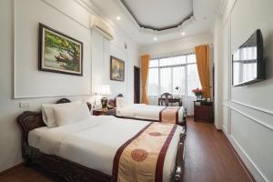 a hotel room with two beds and a window at Hanoi Little Town Hotel in Hanoi