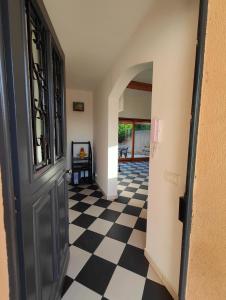 a hallway with a black door and a checkered floor at Votre Évasion Provençale : Villa de Prestige à Marseille in Marseille