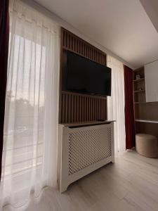 Il comprend un salon doté d'une télévision à écran plat et de rideaux. dans l'établissement Ellie Apartment, à Cluj-Napoca