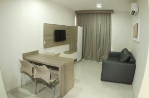 een woonkamer met een tafel en stoelen en een bank bij Atrium Flat in Caldas Novas