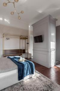 1 dormitorio con 1 cama con manta azul y TV en Вишукані апартаменти у історичному маєтку в парку en Kiev
