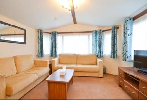 a living room with a couch and a tv at KINSGATE 2 in Shanklin