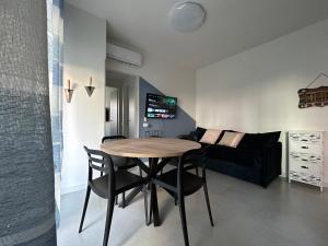 sala de estar con mesa, sillas y sofá en Appartamento Conchiglia-Immobili e Soluzioni Rent, en Lido Adriano