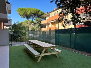 una mesa de picnic de madera en la hierba en Appartamento Conchiglia-Immobili e Soluzioni Rent, en Lido Adriano