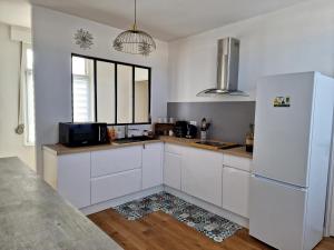 a kitchen with white cabinets and a refrigerator at Appartement Dunkerque in Dunkerque