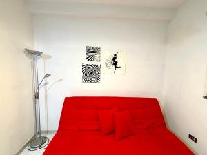 a red bed in a white room with a red couch at Long Life Quartu Poetto in Quartu SantʼElena