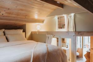 a bedroom with a large bed with a wooden ceiling at refuges in Beauraing