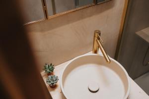 a white sink with a gold faucet in a bathroom at refuges in Beauraing