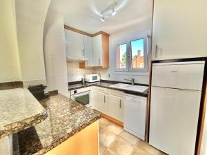 eine Küche mit weißen Schränken und einem weißen Kühlschrank in der Unterkunft Apartamento Varsovia in Oliva
