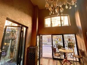a room with two doors and a table and a chandelier at Silver 34 Boutique in Tbilisi City