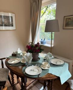 - une table à manger avec des assiettes et des fleurs dans l'établissement TimeOut-Breda, à Breda