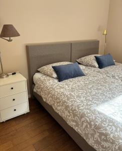 een bed met 2 kussens en een nachtkastje met een lamp bij TimeOut-Breda in Breda