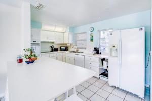 a kitchen with white cabinets and a white refrigerator at Cozy 60's home, city & canal located in Cape Coral
