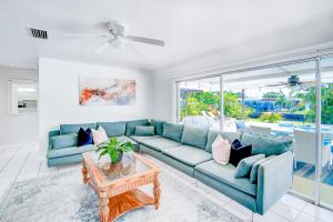 a living room with a blue couch and a table at Cozy 60's home, city & canal located in Cape Coral