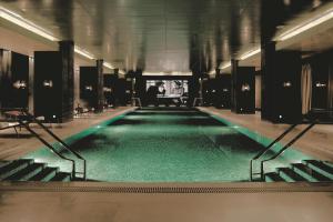 a large swimming pool with green water in a building at The Ritz-Carlton Beijing, Financial Street in Beijing