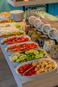 a buffet with many plates of vegetables on a table at Hotel Mazowiecki Łódź in Łódź