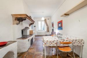 uma sala de jantar com uma mesa e um fogão em Appartamento Valbona nel cuore di Urbino em Urbino