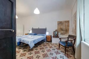 una camera da letto con un letto e una sedia di Appartamento Valbona nel cuore di Urbino a Urbino