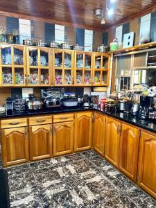 una cocina con armarios de madera, ollas y sartenes en Fisiah Guest house en Nelspruit