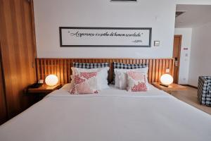 a bedroom with a large bed with two lamps at Hotel Praia Marina by RIDAN Hotels in Praia da Vitória