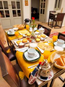 une table avec un chiffon de table jaune et de la nourriture dans l'établissement Riad Dar Chadia, à Marrakech