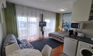 a hotel room with a bed and a living room at Musa Mar studio with balcony panoramic view in the residential area in Quarteira +5 photos