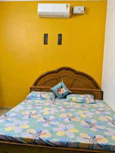 ein Schlafzimmer mit einem Bett mit einer blauen und gelben Wand in der Unterkunft Manu Villa A Royal Stay in Jaipur
