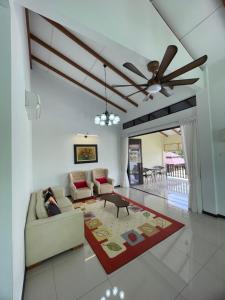 a living room with a couch and a ceiling fan at Traditional Melaka Homestay with Private Pool in Kampong Bukit Katil