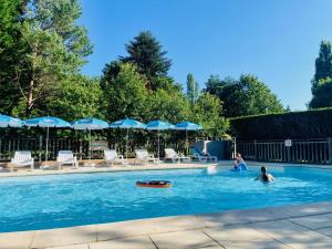 two people swimming in a swimming pool at Flower Camping La Pibola in Camon