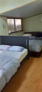 1 dormitorio con 2 camas y ventana. en 椿リゾートみさき, en Shirahama