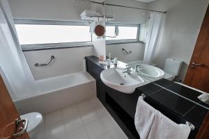 a bathroom with a sink and a tub and a toilet at Hotel Praia Marina by RIDAN Hotels in Praia da Vitória