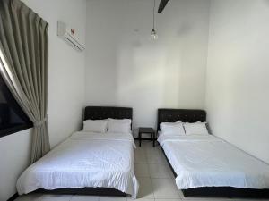 two beds in a room with white sheets at Traditional Melaka Homestay with Private Pool in Kampong Bukit Katil