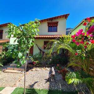 a garden in front of a house with flowers at Green Chales - Vale do Capão in Vale do Capao