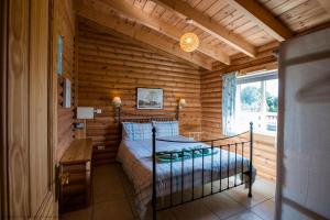 a bedroom with a bed in a log cabin at Kingfisher Lodge in Selby