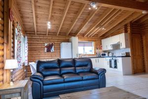 a living room with a leather couch in a kitchen at Kingfisher Lodge in Selby