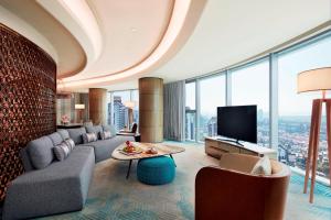 a living room with a couch and a television at Sheraton Guangzhou Nansha Hotel in Guangzhou