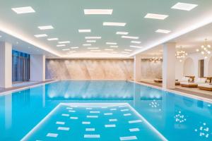 a swimming pool in a hotel lobby with a blue swimming pool at Le Meridien Shanghai Hongqiao,Minhang in Shanghai