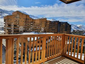 a balcony with a view of a building and mountains at 34 Roche Blanche in Val Thorens