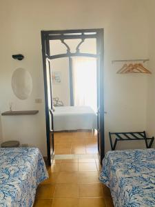 a room with two beds and a door to a bedroom at Isola delle Femmine Apartment in Capaci in Capaci
