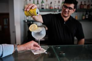 a man pouring a drink in a martini glass at Hotel Praia Marina by RIDAN Hotels in Praia da Vitória