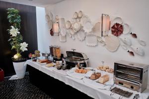 a buffet table with bread and pastries on it at Hotel Praia Marina by RIDAN Hotels in Praia da Vitória