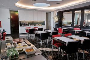 a restaurant with tables and chairs and a bar at Hotel Praia Marina by RIDAN Hotels in Praia da Vitória