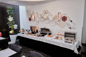 a table with bread and plates on a wall at Hotel Praia Marina by RIDAN Hotels in Praia da Vitória